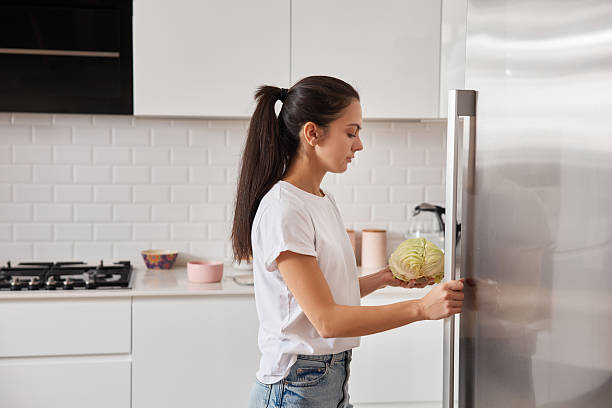 istock Woman placing fresh cabbage in refrigerator 2255056519