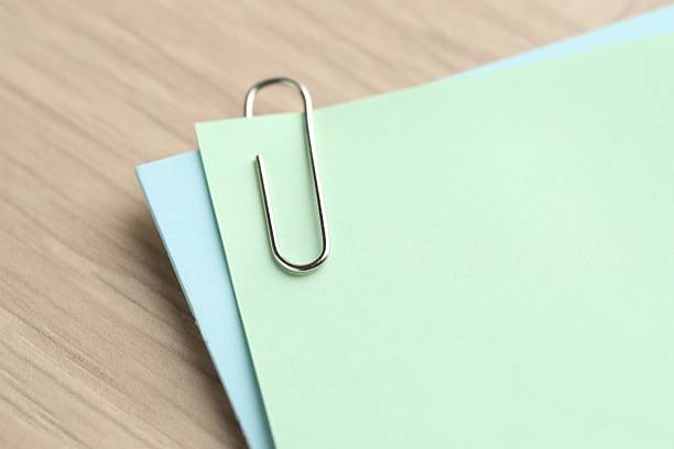 Paper notes with clips on wooden table, closeup. Space for text