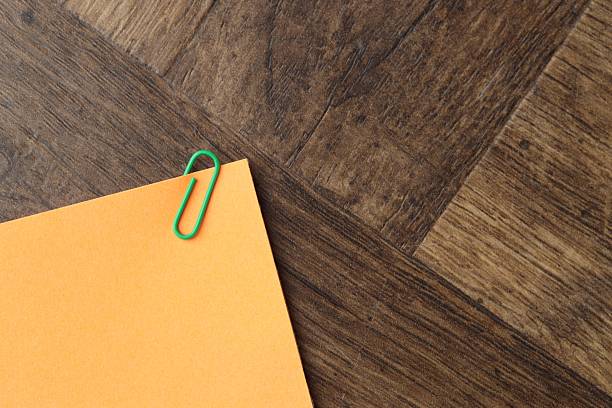 Paper note with clip on wooden table, top view. Space for text