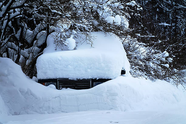 The entire passenger car is covered (except for the radiator grille) with snow in a heavy snowstorm. Northern winter