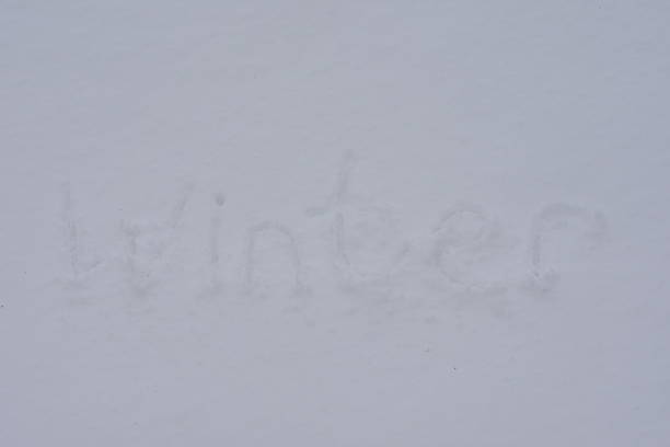 Winter lettering on fresh white snow. Simple seasonal background with copy space.