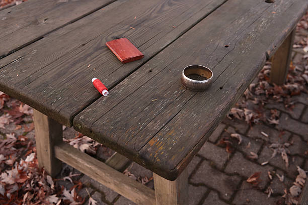 Weathered wooden table with coffee, wallet, and thread