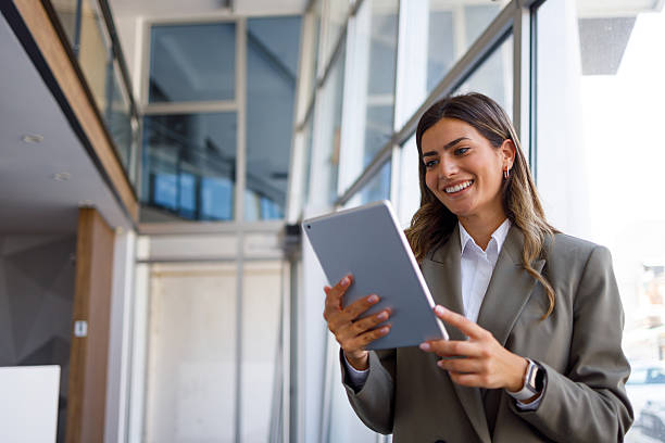 istock Professional businesswoman smiling while using digital tablet, connecting with technology in a modern office environment 2255074811
