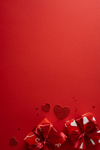 Vivid vertical red backdrop with glitter hearts and wrapped gifts creates a festive, romantic mood for Valentineâs Day greetings and love themes. Ideal for cards, promos, and gift ideas