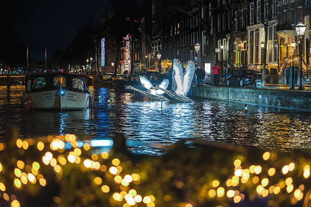 Amsterdam, Netherlands - January 3, 2026: Historic buildings from boat reflected in calm winter canal waters