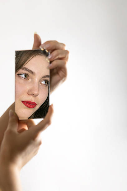 portrait of beautiful young woman with comb looking at herself in the wonderful mirror.  Portrait with bokeh