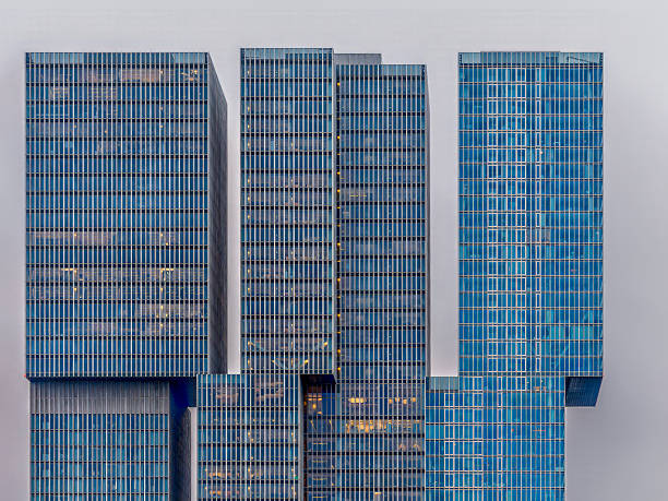 Tall skyscrapers (The Rotterdam) with glass facades dominate the Rotterdam skyline, reflecting the city’s modern architecture. The structures showcase unique designs.