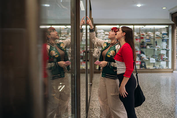 istock Women shopping and pointing at a window display 2255085069