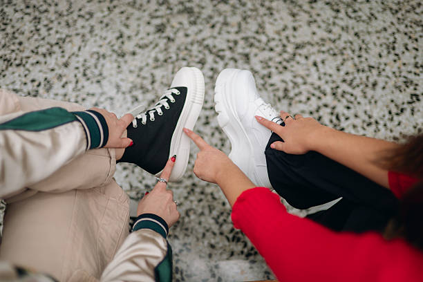 istock Two women comparing trendy black and white platform sneakers 2255085168