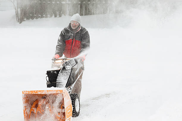 Mid adult man using snowblower after heavy snowfall at backyard