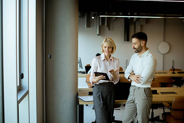 istock Two professionals discussing work in a modern office during the day 2255087174