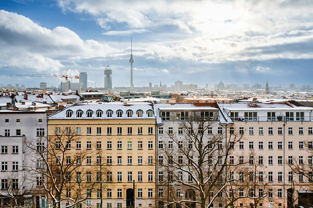 high angle view over the roofs of snowy central berlin with tv tower in the background