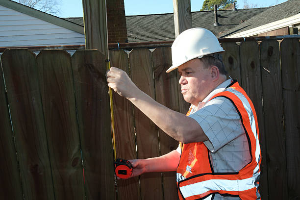 istock Construction worker measuring fencing for repair 2255092311