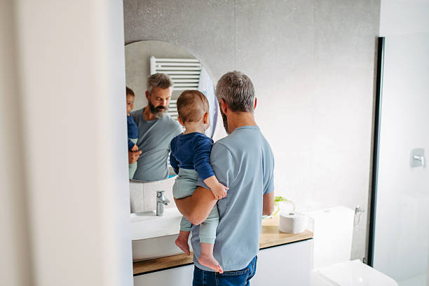 istock Morning routine in bathroom, father combing son hair. 2255095577