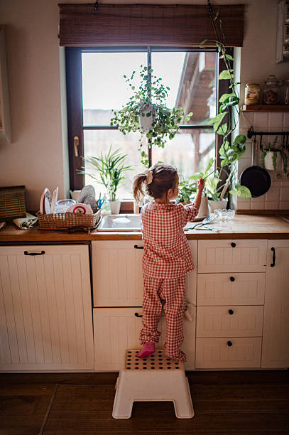 istock Independent child doing dishes at home. 2255096392