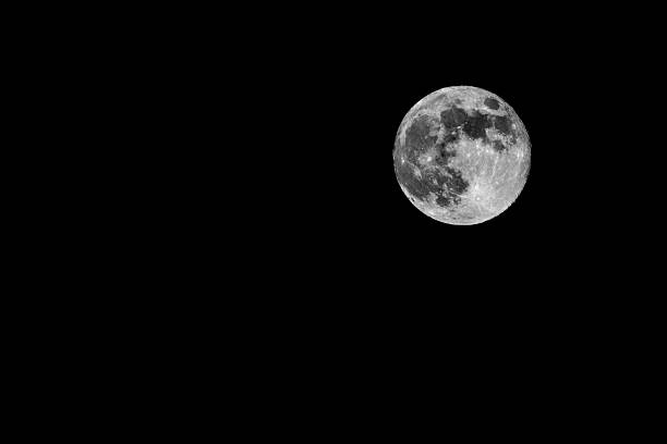 Detailed full moon isolated against a deep black night sky. Minimalist astronomical scene with strong contrast, ideal for science, space, mystery, astrology, and conceptual backgrounds with copy space.
