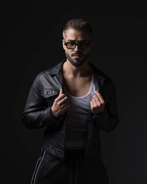 istock cool fashion man with sunglasses pulling and adjusting black leather jacket 2255100182