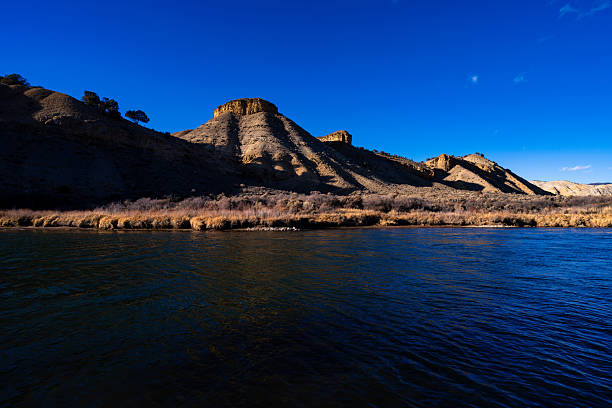 Scenic landscape with tthe Colorado River in warm afternoon light flowing through scenic canyon and mountains in western Colorado USA.