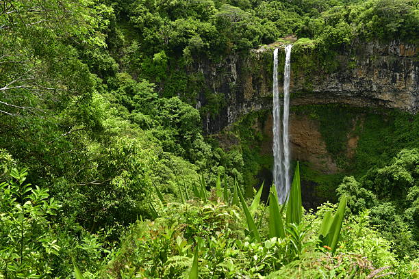 An idyllic view of a classic waterfall created by a sink hole collapse which has eroded down the hill and flowing to the coast.