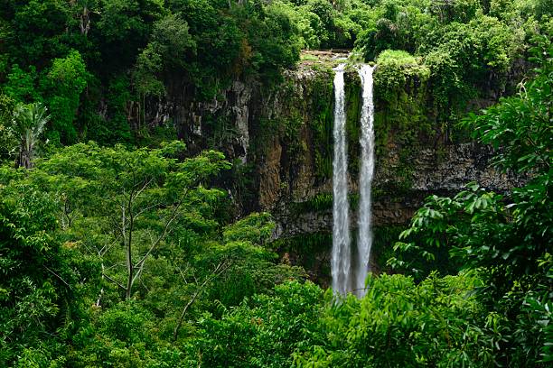 An idyllic view of a classic waterfall created by a sink hole collapse which has eroded down the hill and flowing to the coast.