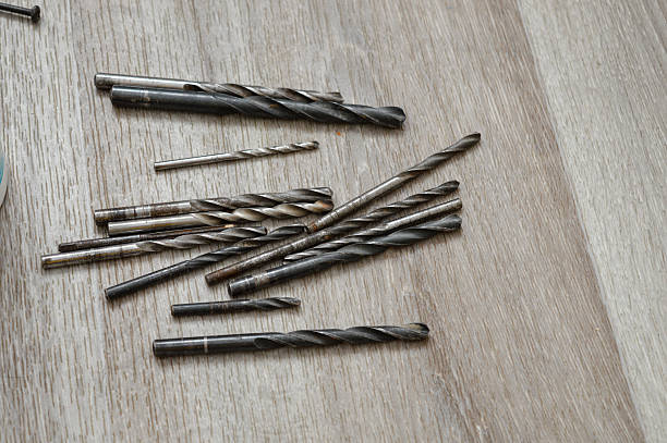 istock Assorted metal drill bits scattered on a wooden surface. Suitable for themes of DIY, carpentry, construction, workshop tools, repair work, and home improvement. 2255112059