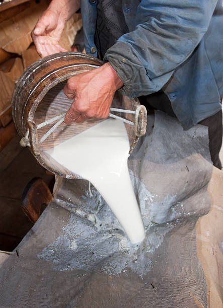 istock Pouring Fresh Raw Milk through a Strainer in a Traditional Dairy 2255117395