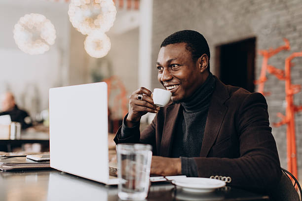 istock African American man working remotely, drinking coffee, smiling 2255117584