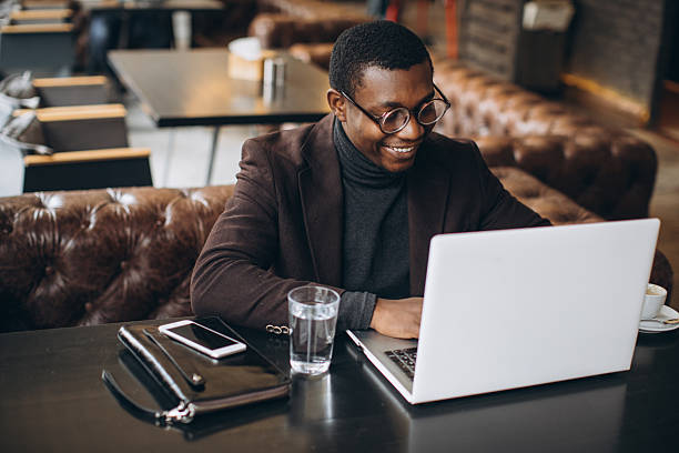 istock Young black businessman using laptop at a cafe 2255117630
