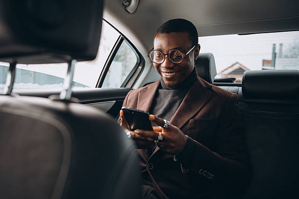 istock Black businessman checking smartphone during car commute 2255117858