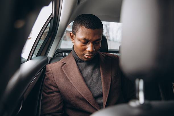 istock Thoughtful businessman riding in car backseat looking down 2255117879