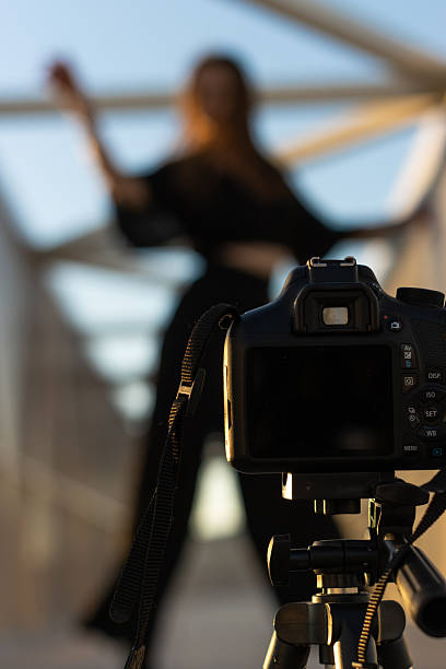 istock Digital camera filming female model dancing outdoors at sunset 2255120421
