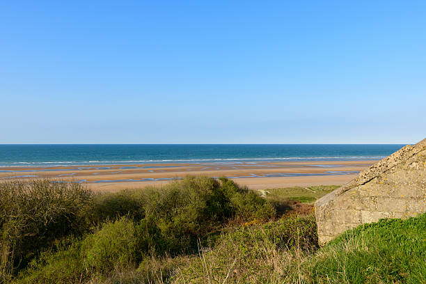 Arromanches beach in Normandy, with ruins of bunkers, sunny day in summer