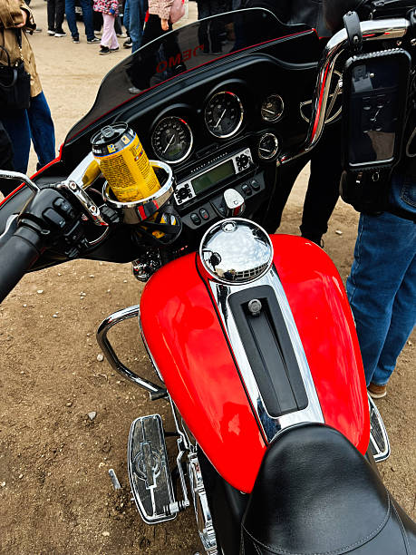 Ternopil,Ukraine - November 29, 2025: Red Harley-Davidson Electra Glide Ultra Limited motorcycle tank and dashboard with chrome gauges amid a crowd at a public outdoor show.