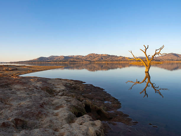 istock Late afternoon sun on reflection lake and red dirt 2255123055