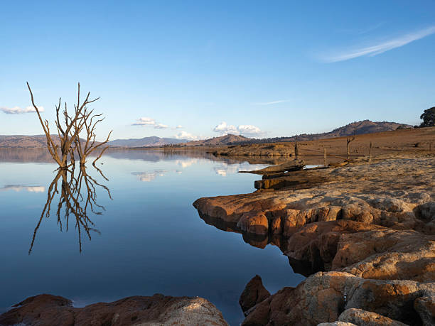 istock Late afternoon sun on reflection lake and red dirt 2255123075