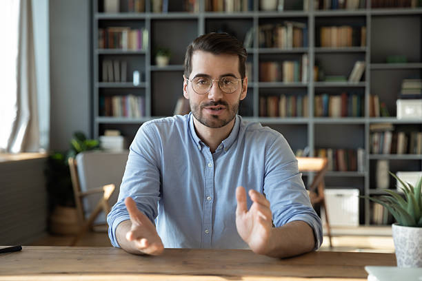 istock Screen view young male sitting at desk speaking via videocall 2255127420