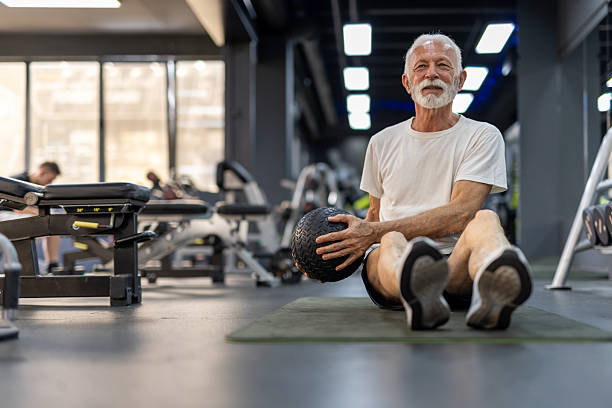 istock Fit Elderly Man Exercising With Weighted Ball In Gym 2255127494
