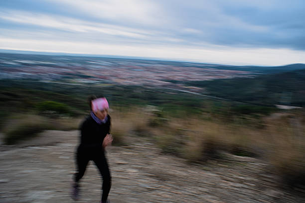 A female athlete training up a mountain, with motion blur in the image.