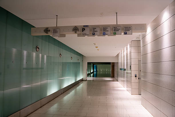 View of underground corridor with directional signs and escalator. Montreal, Canada - December 18, 2025.