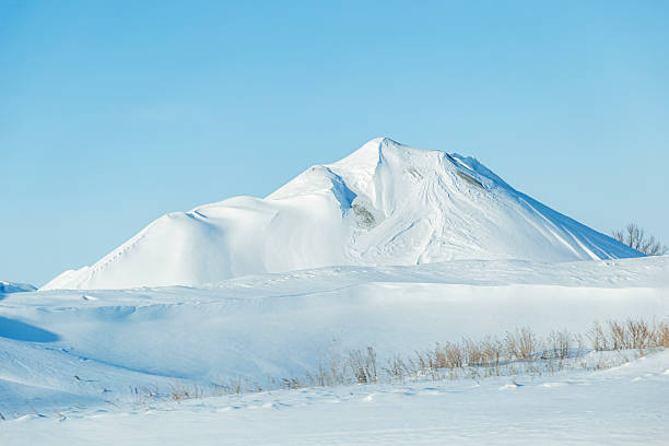 A blanket of snow covers a large gravel pile in a northern Minnesota gravel pit.