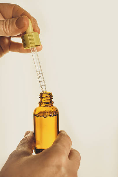 istock Hand removing dropper from an amber bottle with liquid serum inside 2255141065