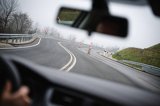 Cars and trucks travel along the M5 motorway bordered by trees showing autumn colors. The highway curves gently through the countryside under a partly cloudy sky, capturing a calm moment of everyday road traffic.
