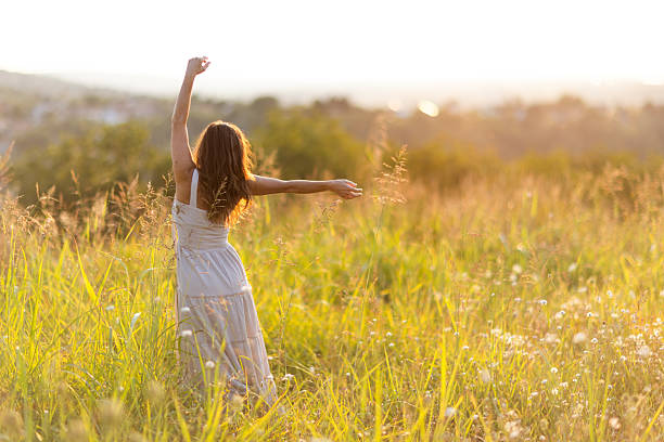 istock Woman Enjoying Freedom in a Serene Sunlit Meadow 2255141441