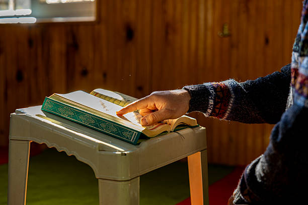 Person reading the holy quran inside a mosque with spiritual atmosphere, islamic worship concept and religious devotion
