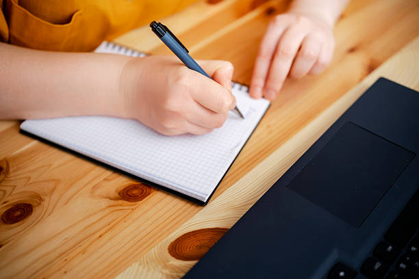 istock Close up of hands writing in notebook on wooden table, simple workspace with laptop, mindful work and productivity lifestyle concept 2255156613