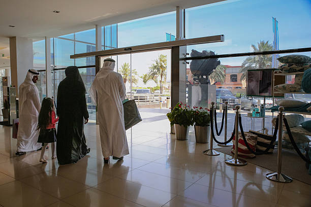 istock Middle Eastern three generation family walking together inside modern shopping mall holding hands in bright indoor corridor 2255159251