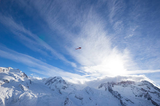 Helicopters fly through the swiss alps throughout winter taking vacationers on joy flights as well as providing safety against avalanches and rescue