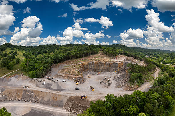 Industrial open-pit mining site with limestone quarry at mountain hillside.