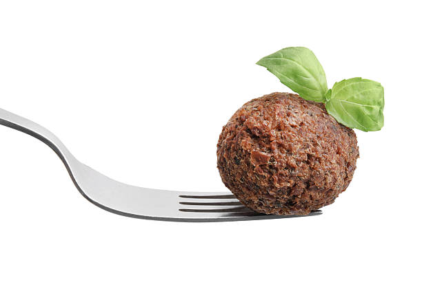 Delicious falafel ball, basil and fork isolated on white