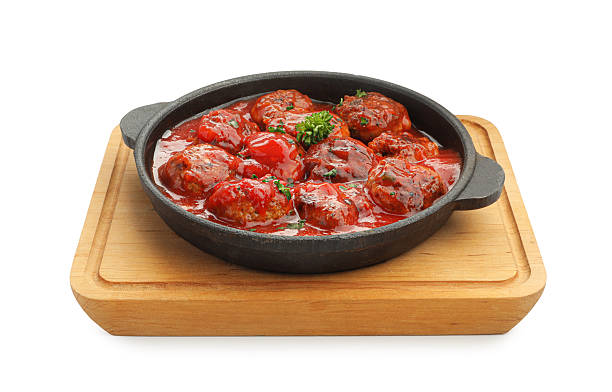 Delicious meatballs with tomato sauce in baking dish isolated on white